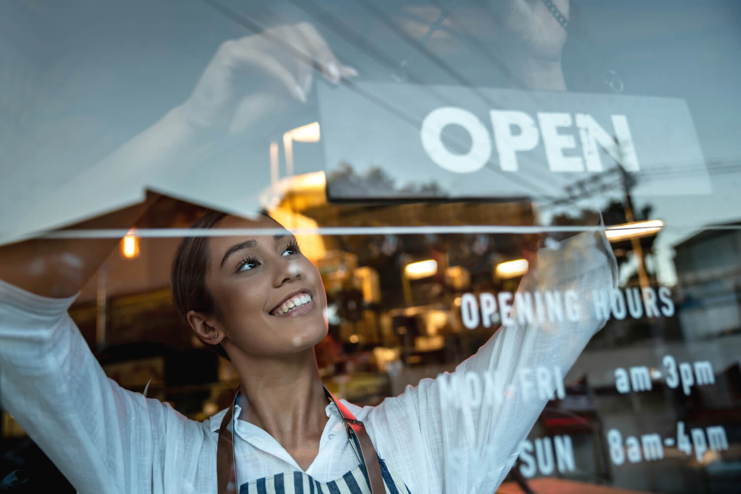 Shop owner with an OPEN sign